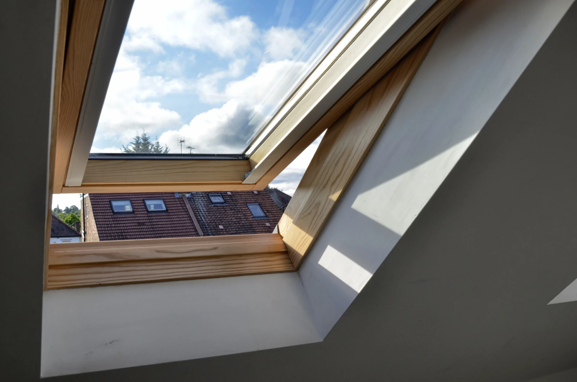 Timber roof window opened from inside a finished loft room