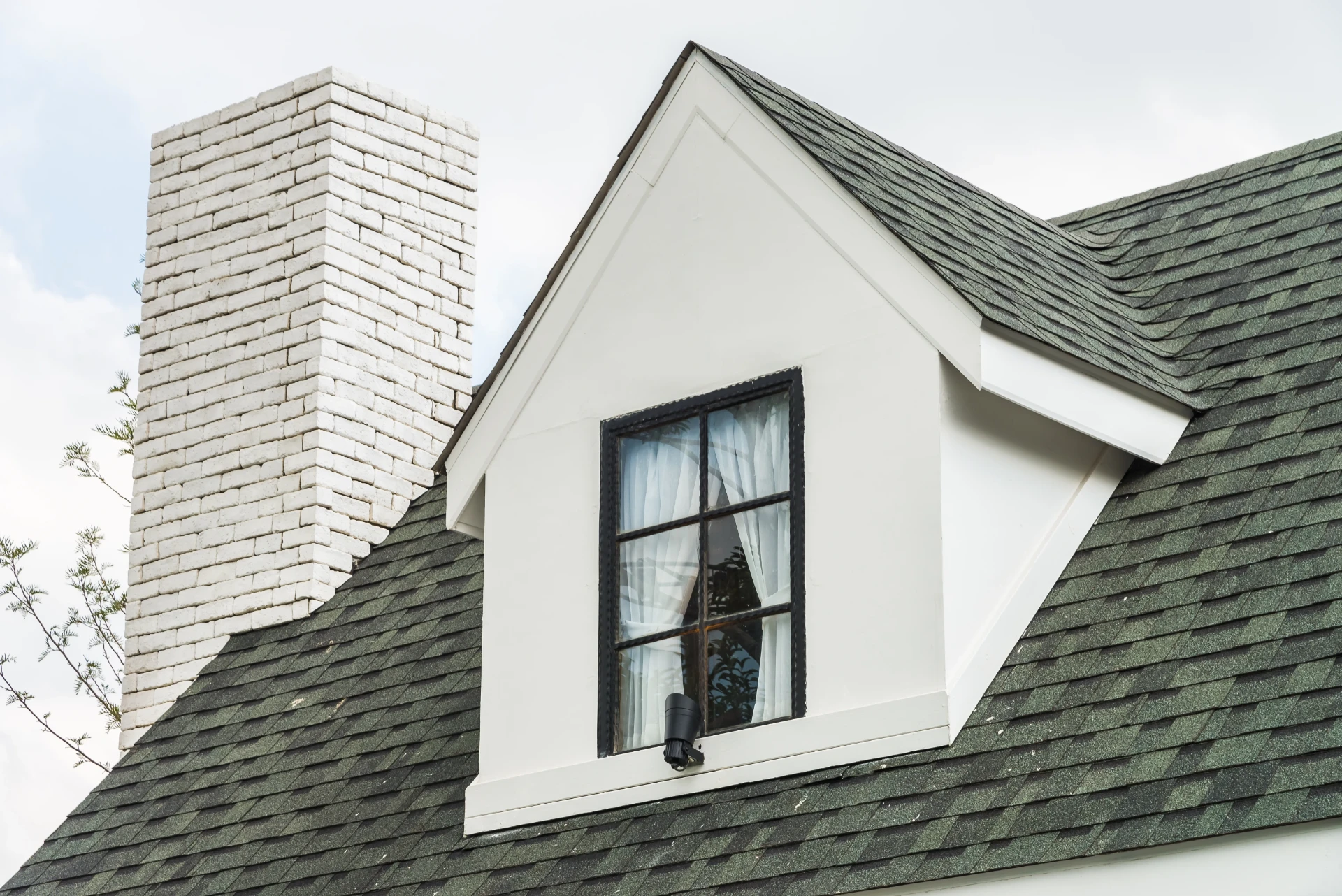 White dormer window and rendered chimney set into a newly covered pitched roof