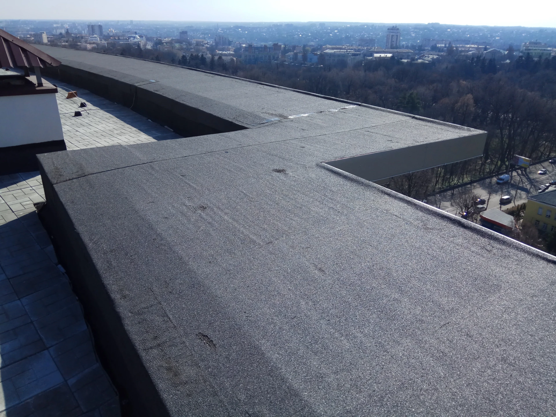 Flat roof and parapet edge overlooking rooftops near Poole